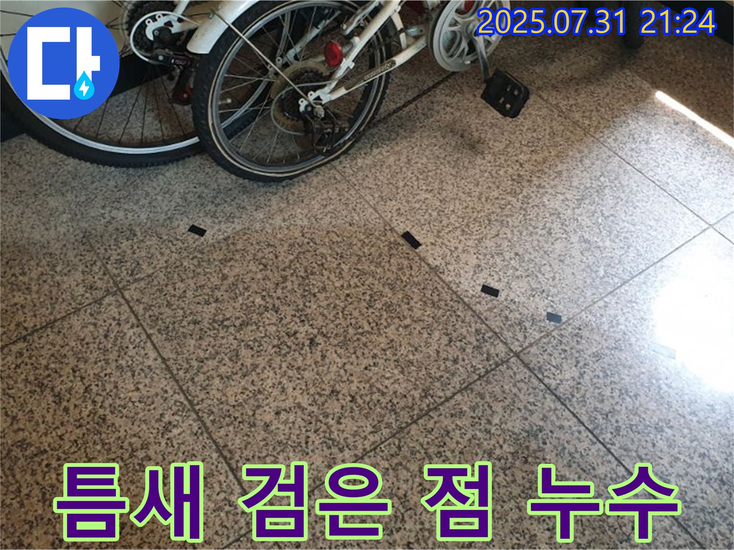 고양시 덕양구 동산동 누수 - 타일 틈새의 작은 검은 점은 누수의 초기 증상일 수 있으며, 자전거 옆이라 더욱 주의 깊게 살펴봐야 합니다