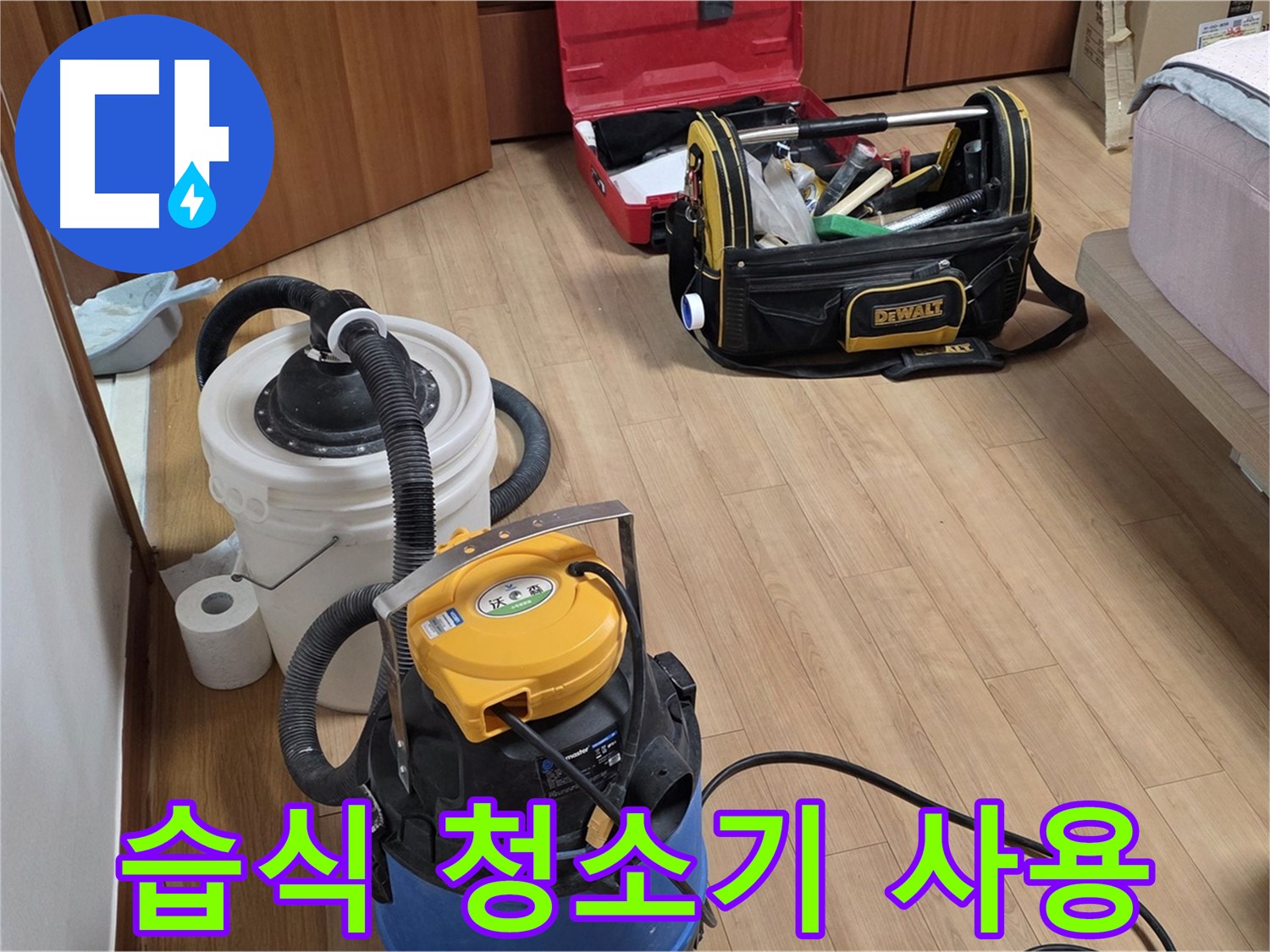 습식 청소기를 사용하여 누수로 인한 물기를 깨끗하게 제거하는 모습입니다 - 쾌적한 환경을 위해 노력합니다.