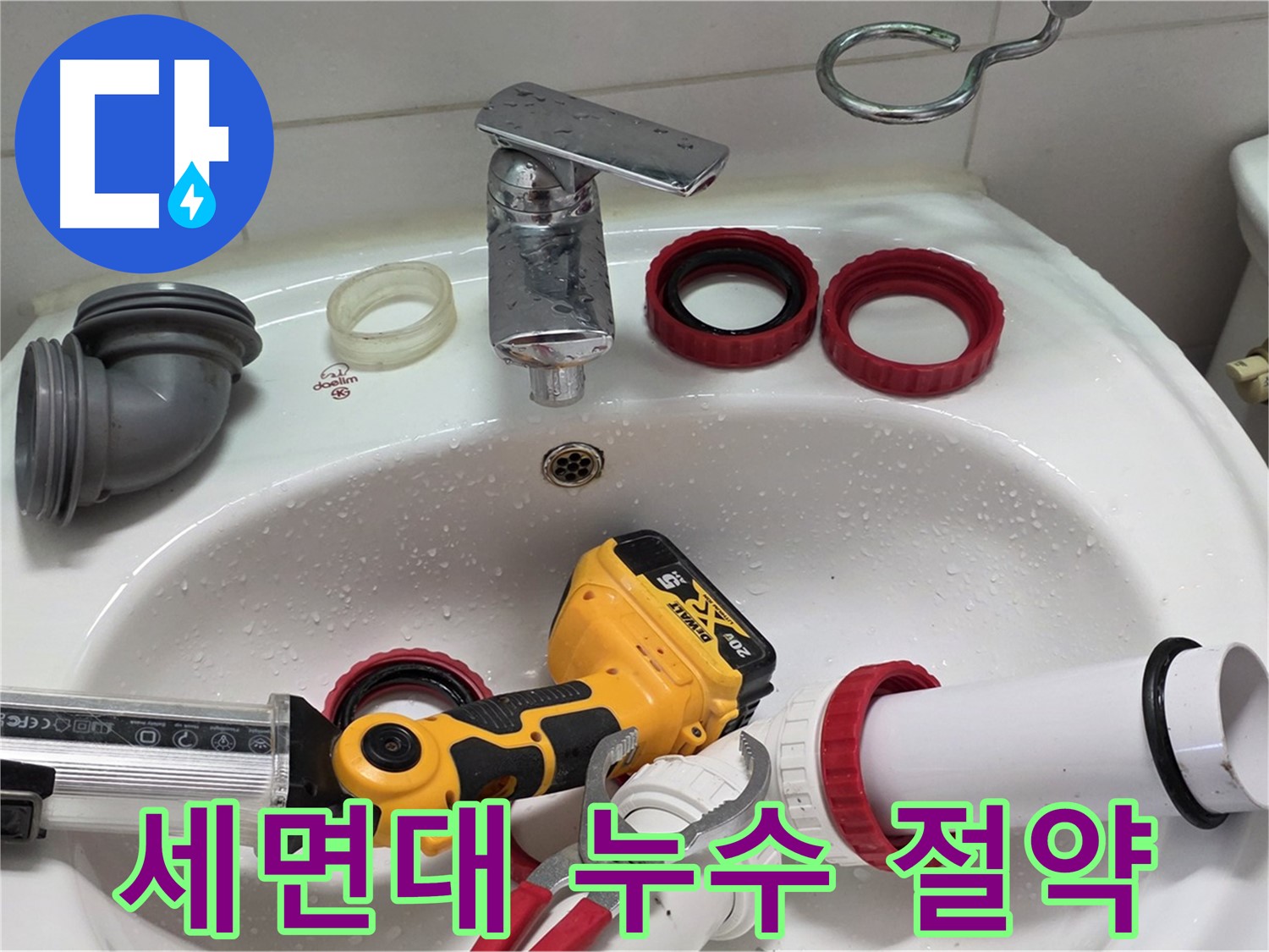 세면대 근처에 정리된 배관 연결 소켓과 실란트 작업 도구