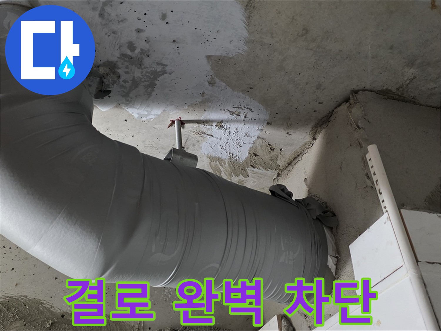 은색 테이프로 마감된 천장 내부의 굴곡진 PVC 배관