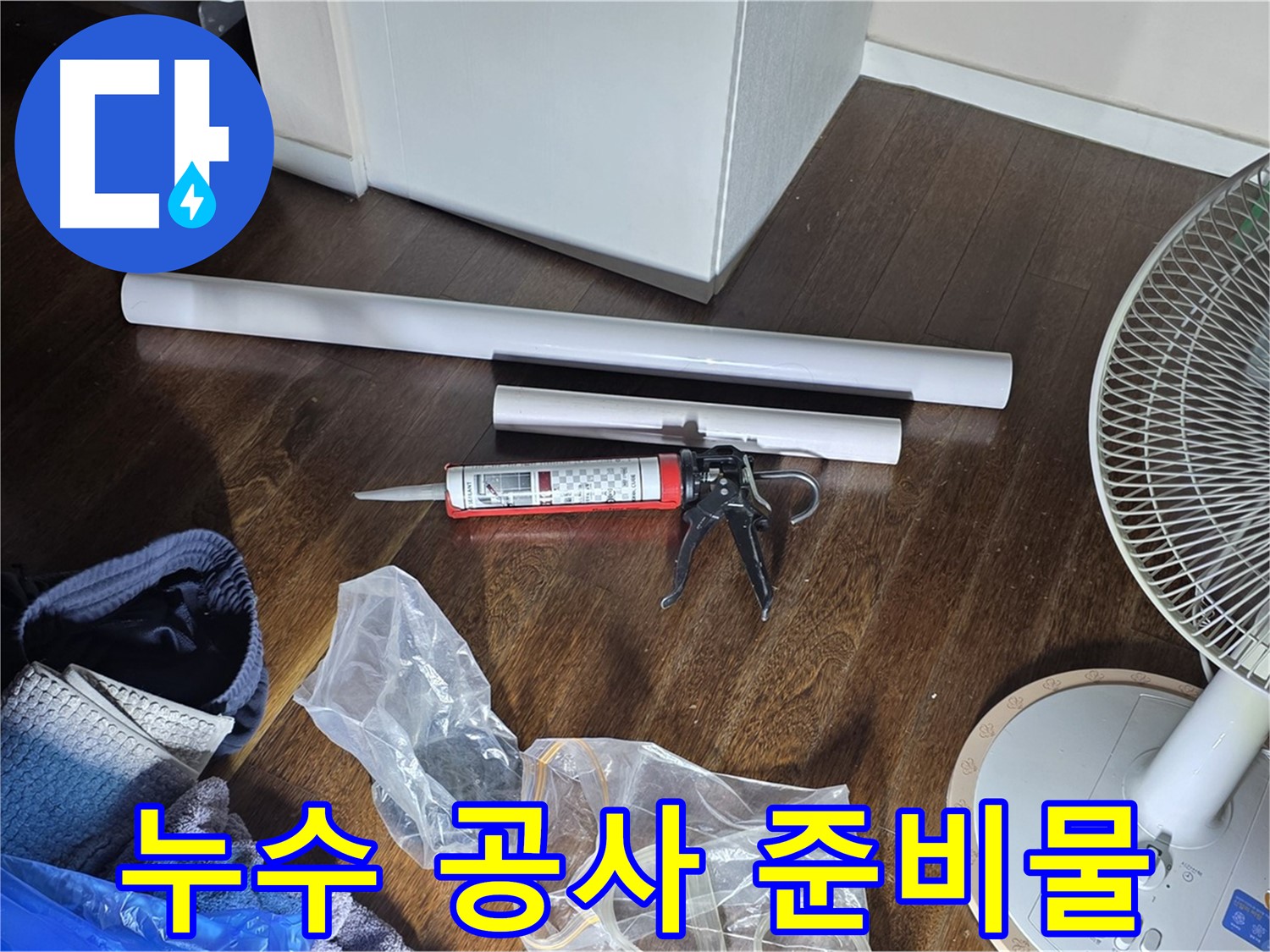 누수 공사를 위한 준비물 - 배관, 실리콘, 공구 등이 가지런히 놓여 있습니다.