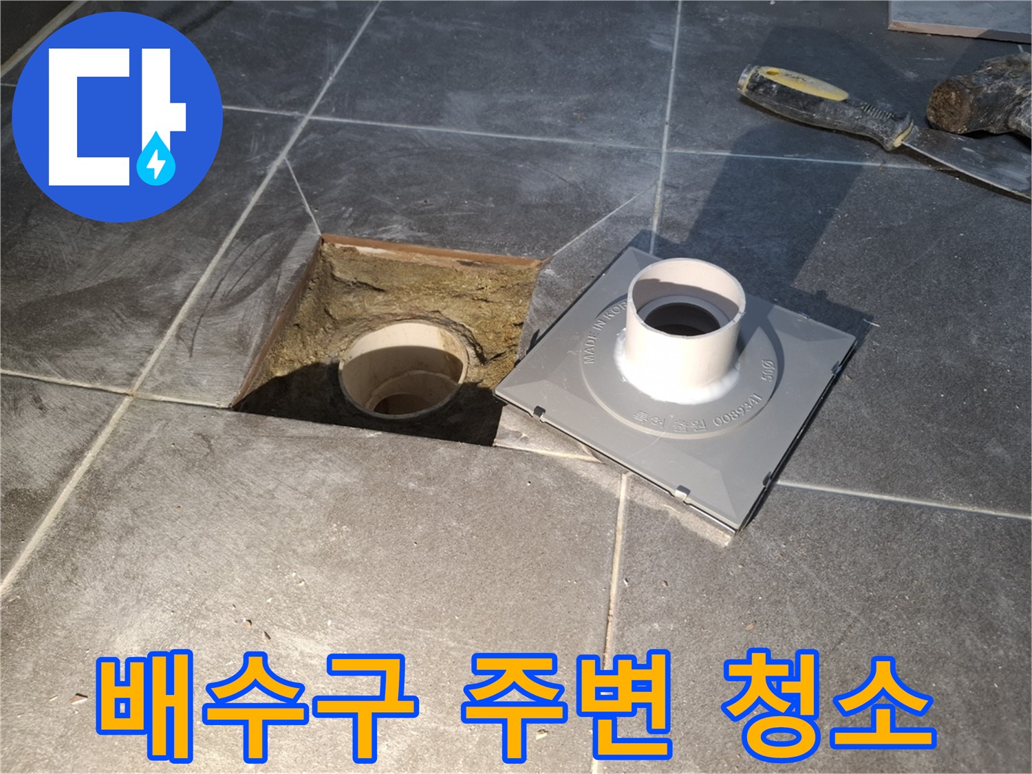 홍은빌라 배수구 주변 청소 - 새 배수구 설치 전에 주변을 깨끗하게 청소하는 모습입니다.