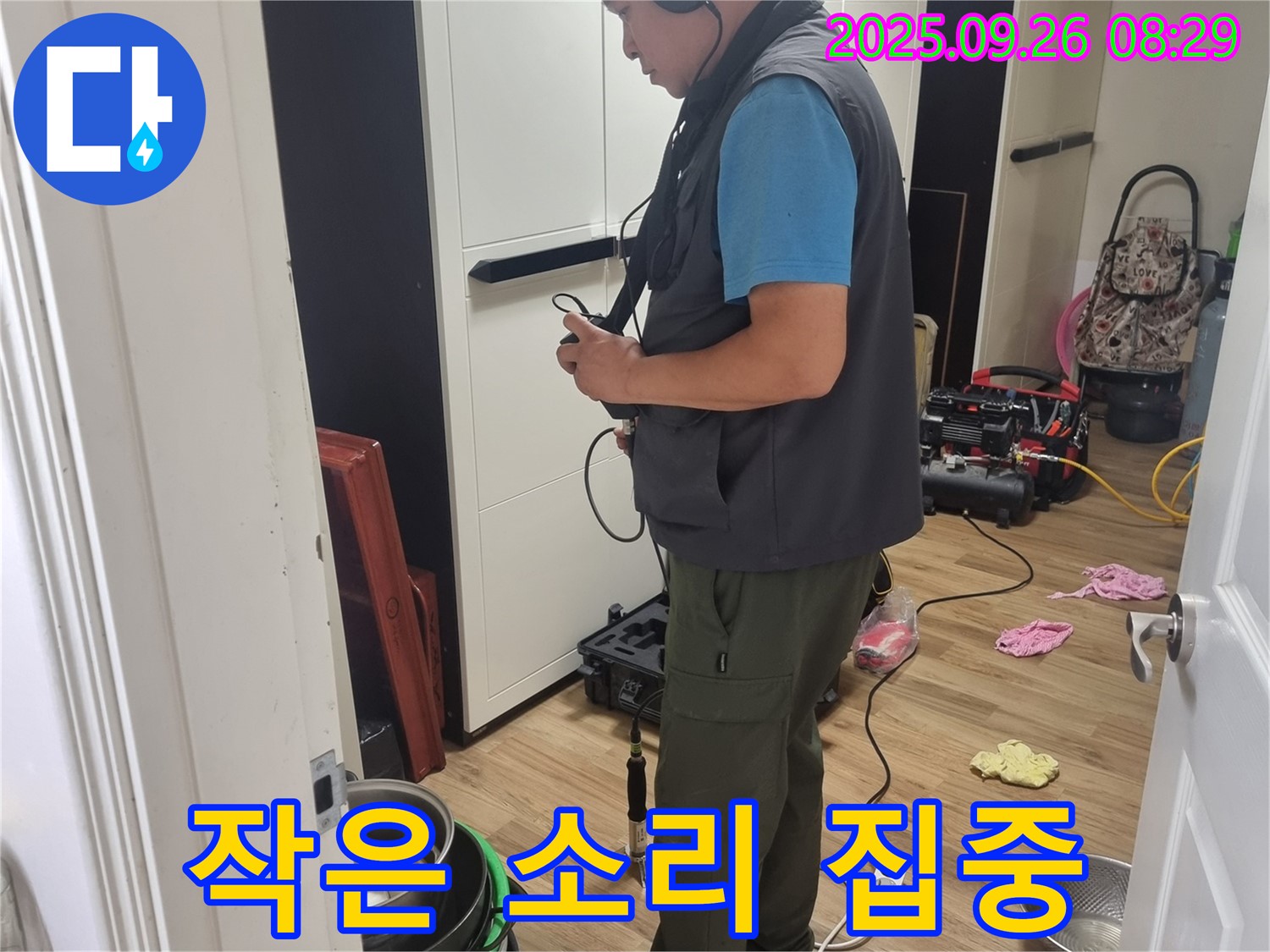 봉천동 누수 현장에서 - 누수 탐지 전문가가 작은 소리에도 귀 기울이며 - 누수 위치를 탐색하는 모습입니다.