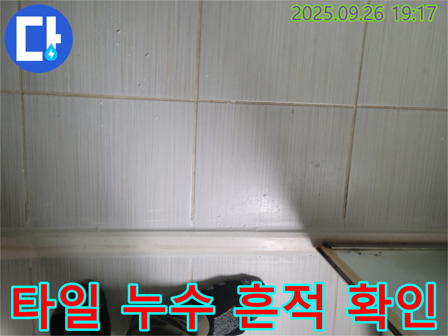 동두천 생연동 누수 - 욕실 타일 표면에 나타난 누수 흔적을 자세히 확인하고 있습니다.