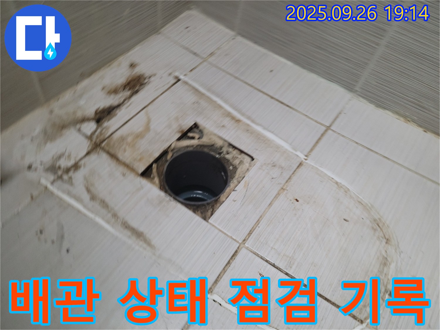 동두천시 하봉암동 누수 - 배수구 주변 타일 철거 후 배관 상태를 점검하고 사진으로 기록하는 모습