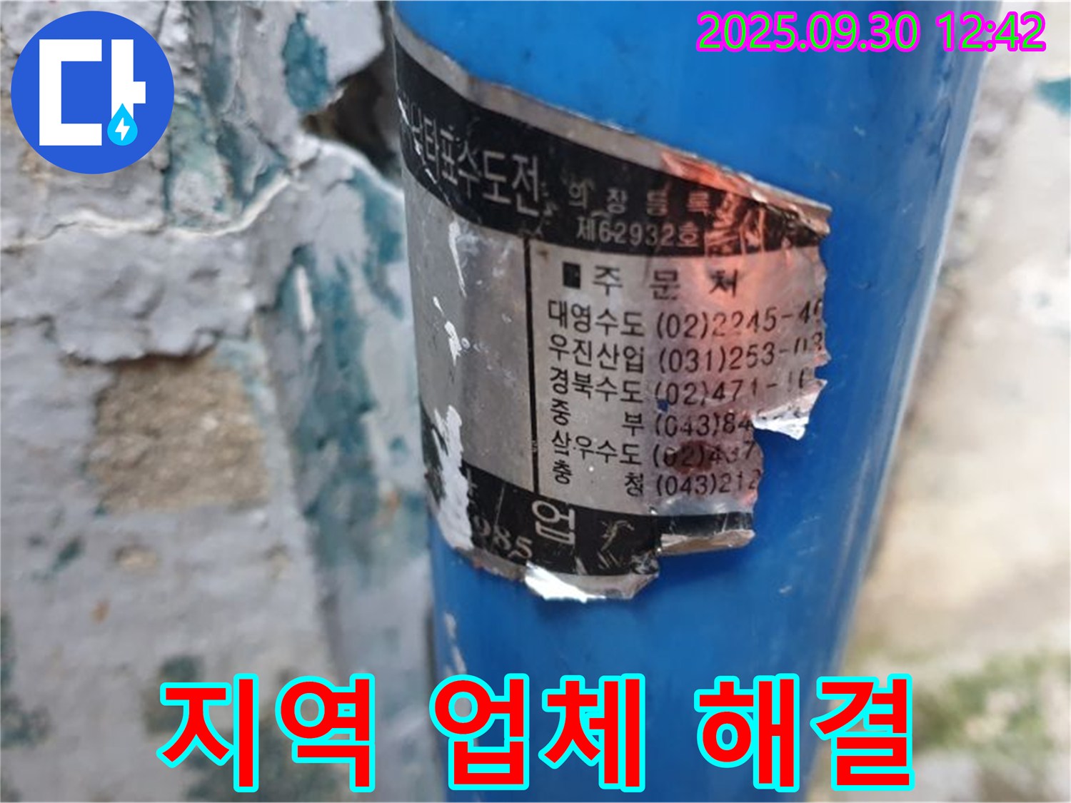 오래된 수도 배관에 부착된 스티커 - 다양한 지역의 시공 업체 정보가 상세하게 기재되어 있습니다.