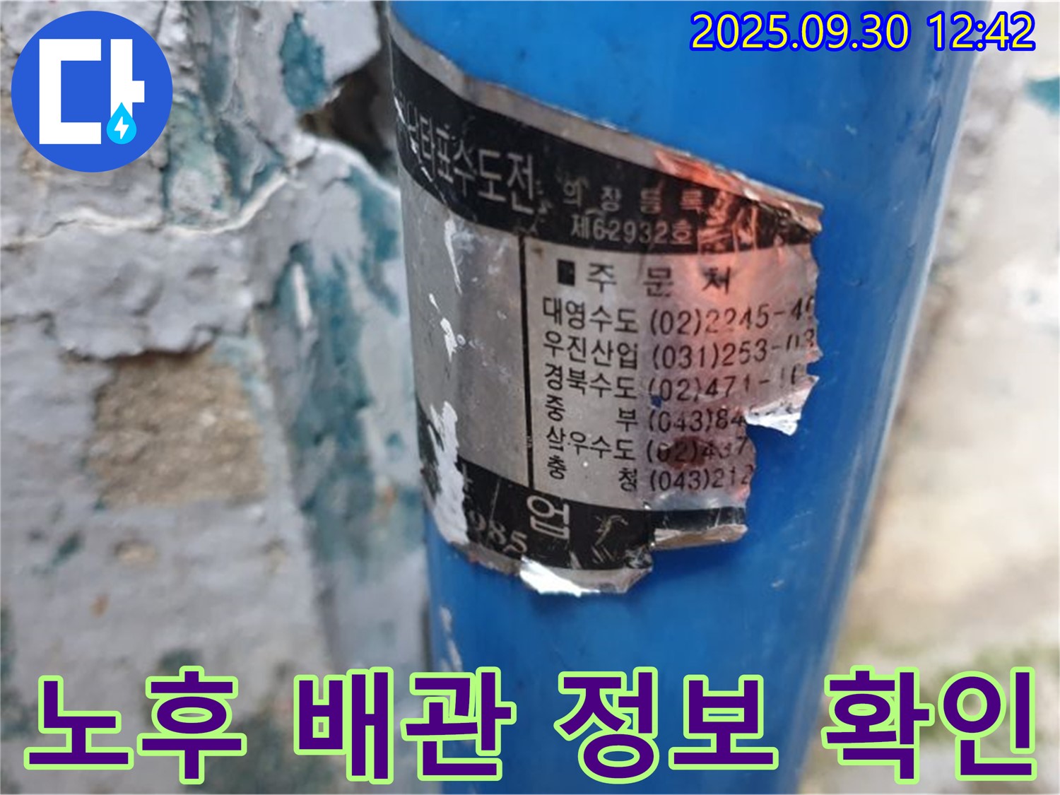 오래된 수도 배관에 부착된 스티커 - 배관 시공 업체 정보와 연락처가 희미하게 남아 있습니다.