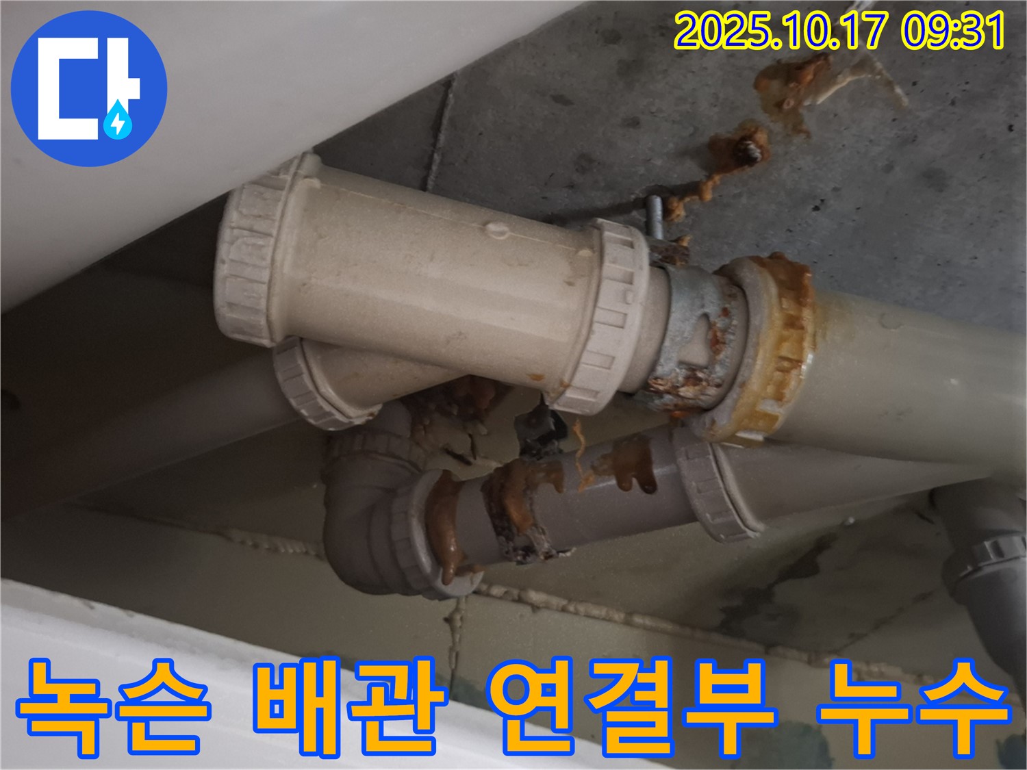 녹슨 배관 연결부 누수 - 배관 연결 부위가 심하게 녹슬어 누수가 발생하고 있습니다 - 즉시 보수가 필요합니다.