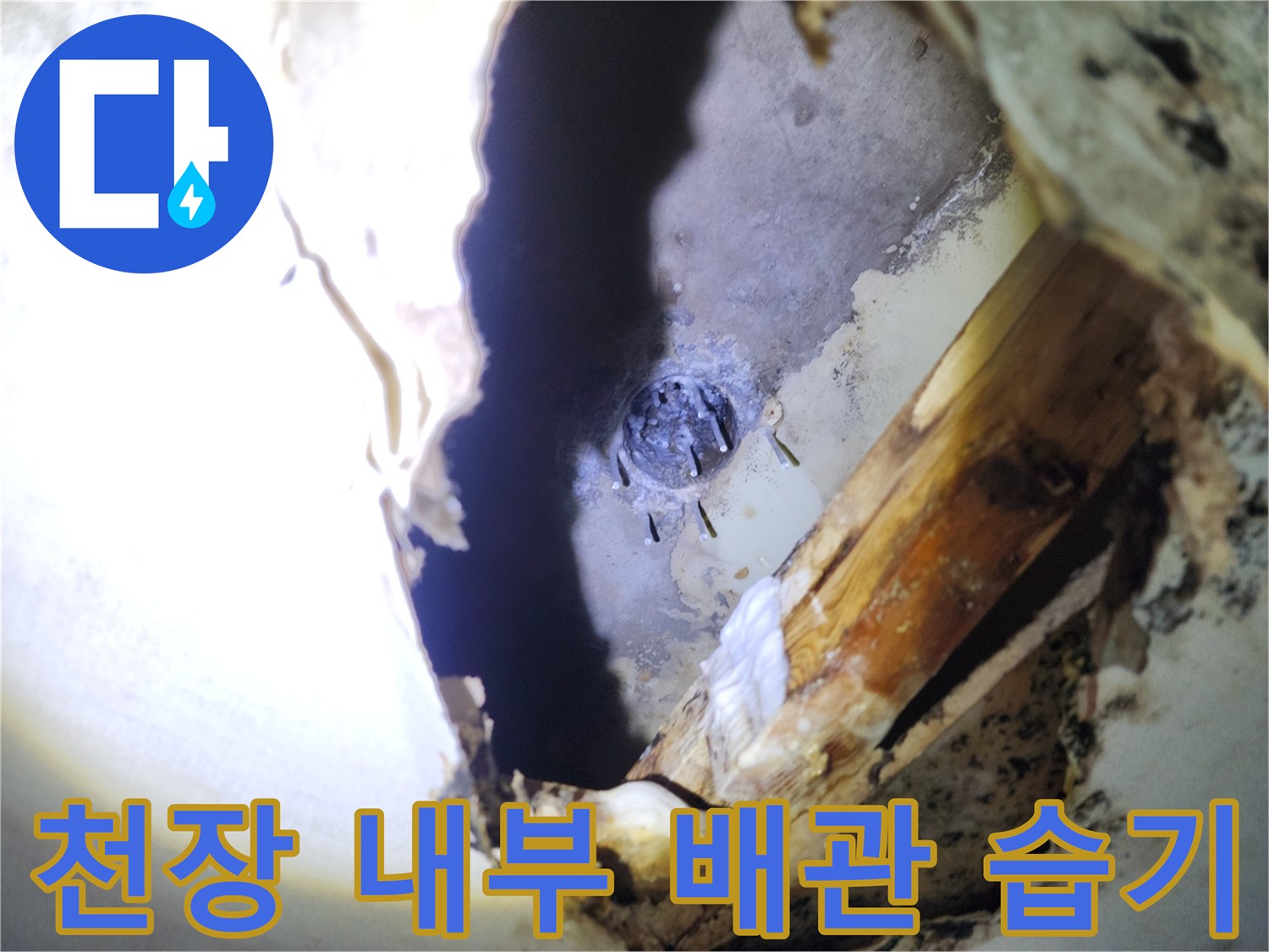천장 절개 부위 내부에 보이는 젖은 배관 연결부