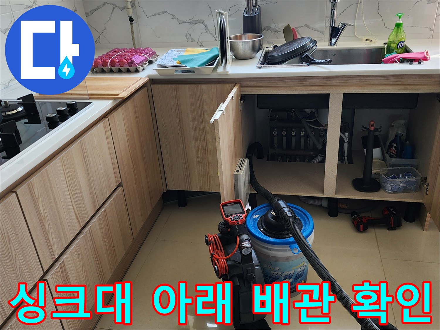물샘 현상이 발견된 싱크대 하부장 내부의 배관 연결 상태를 점검하고 있습니다.