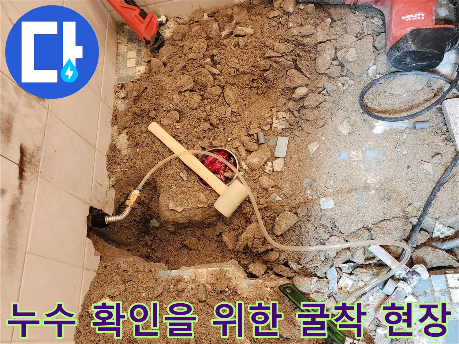 화장실 바닥-배관 누수 부위를 드러내기 위해 파쇄된 콘크리트와 도구