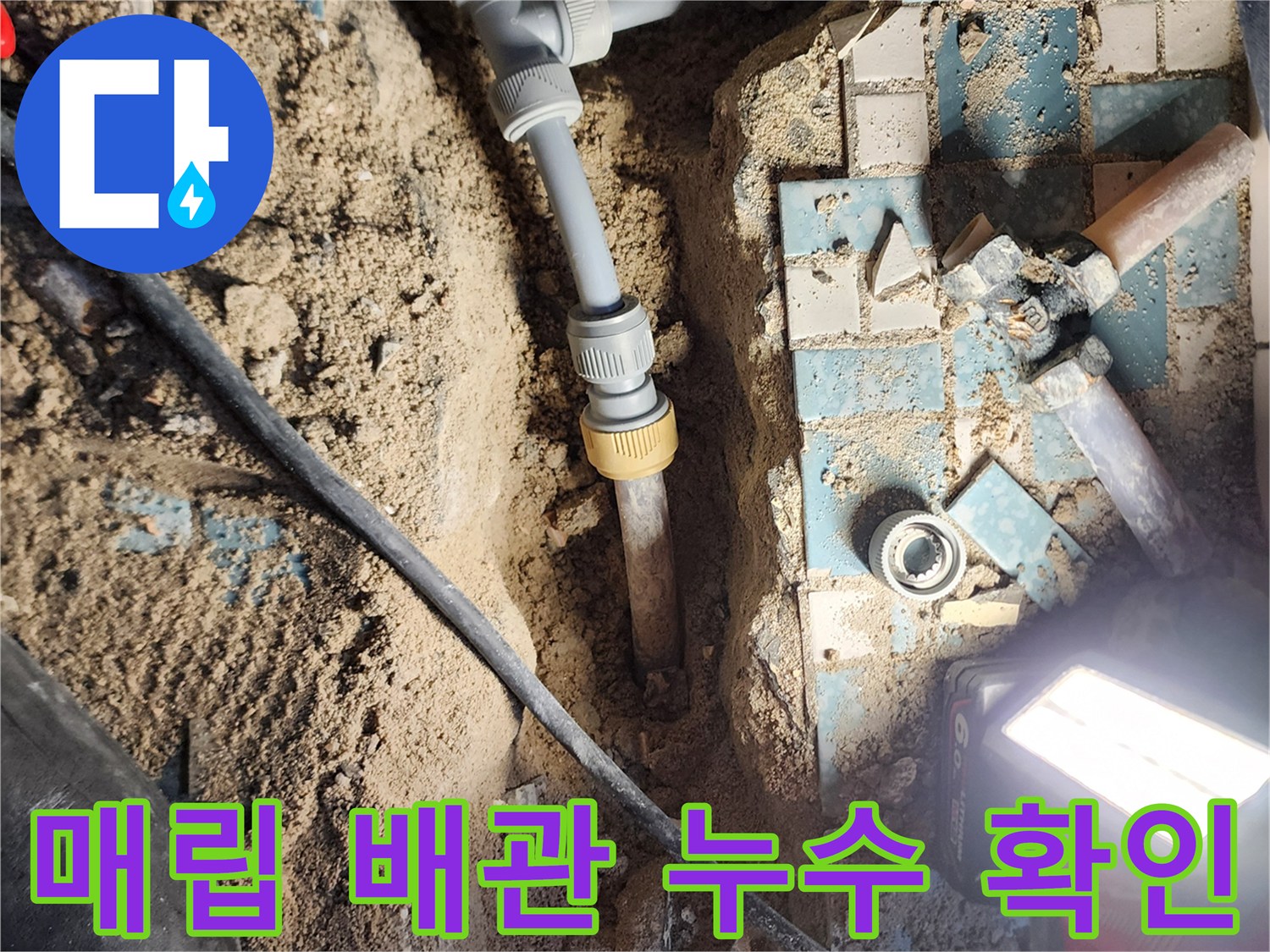 흙과 콘크리트 사이로 드러난 노후 금속 배관과 교체된 신규 배관의 모습