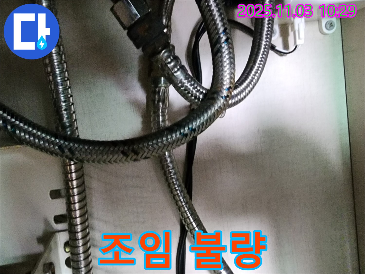 세탁기 급수 호스 연결 부위가 제대로 조여지지 않아 누수가 발생하는 모습 - 간단한 조임 작업으로 해결 가능합니다.