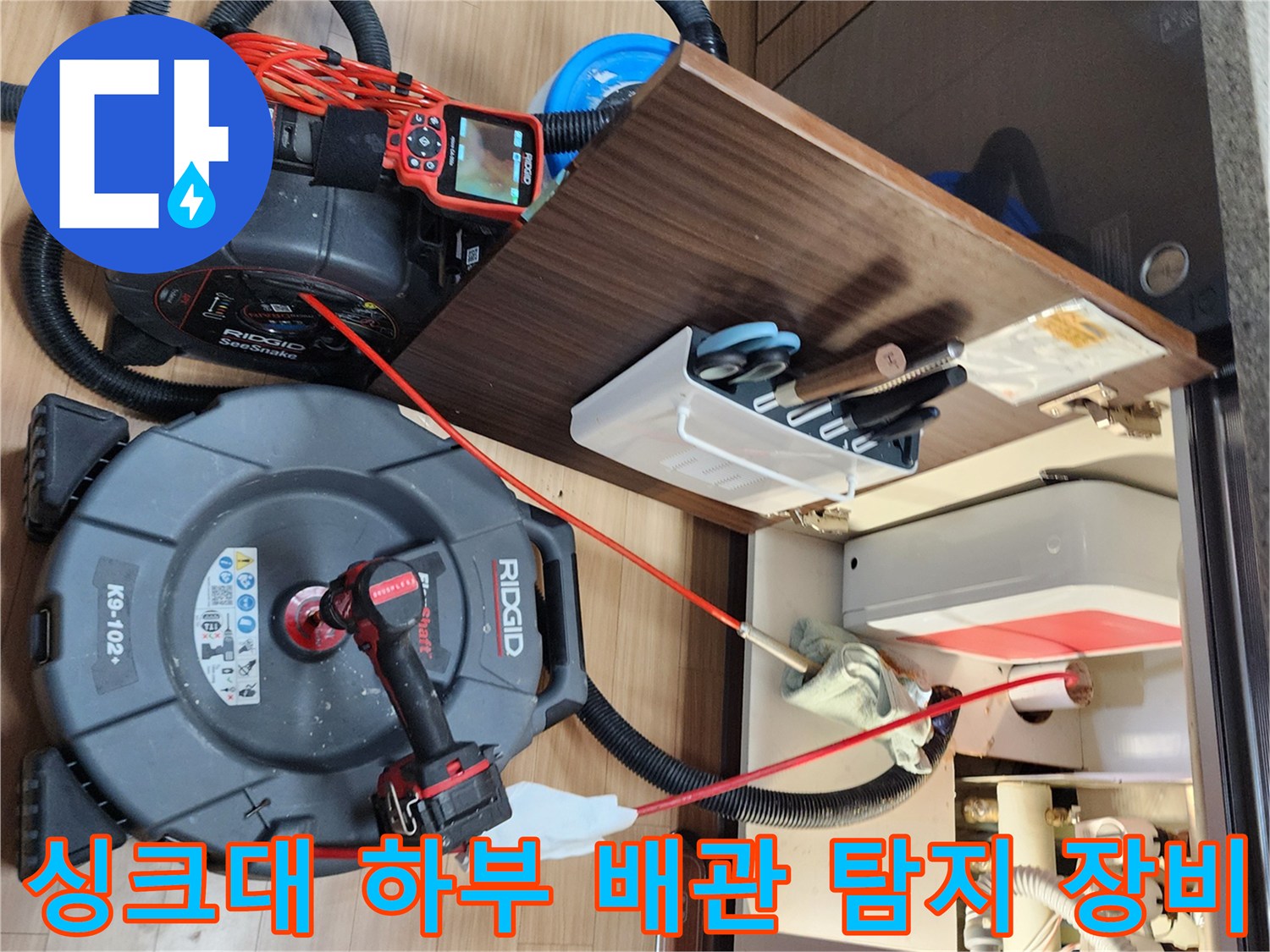 싱크대 아래쪽 배관을 점검하기 위해 배치된 내시뮬레이션 카메라와 압력 측정기입니다.