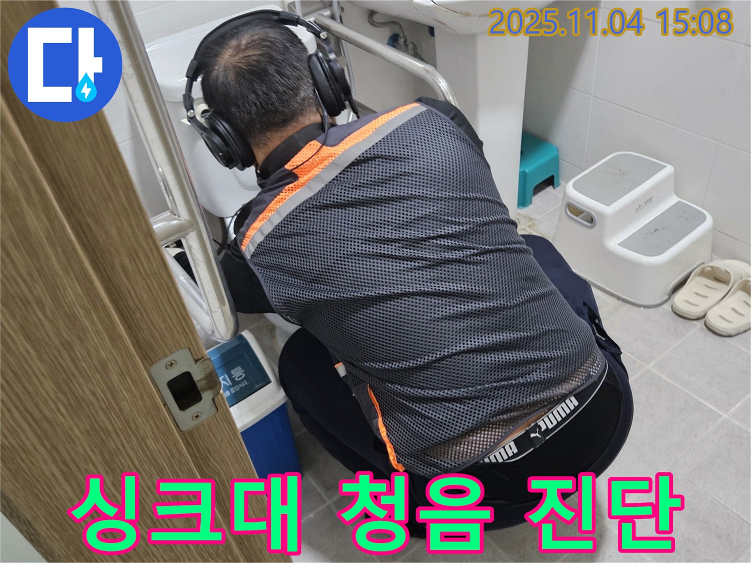 누수 전문가가 싱크대 아래에서 청음 탐지 장비를 사용하여 누수 위치를 찾고 있습니다 - 꼼꼼한 탐지로 숨은 누수까지 완벽하게 진단합니다.