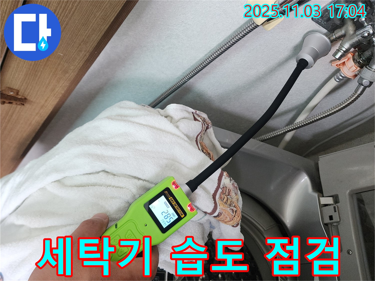 세탁기 습도 점검 - 습도 측정기로 세탁기 주변의 습도를 꼼꼼하게 점검하고 있습니다.