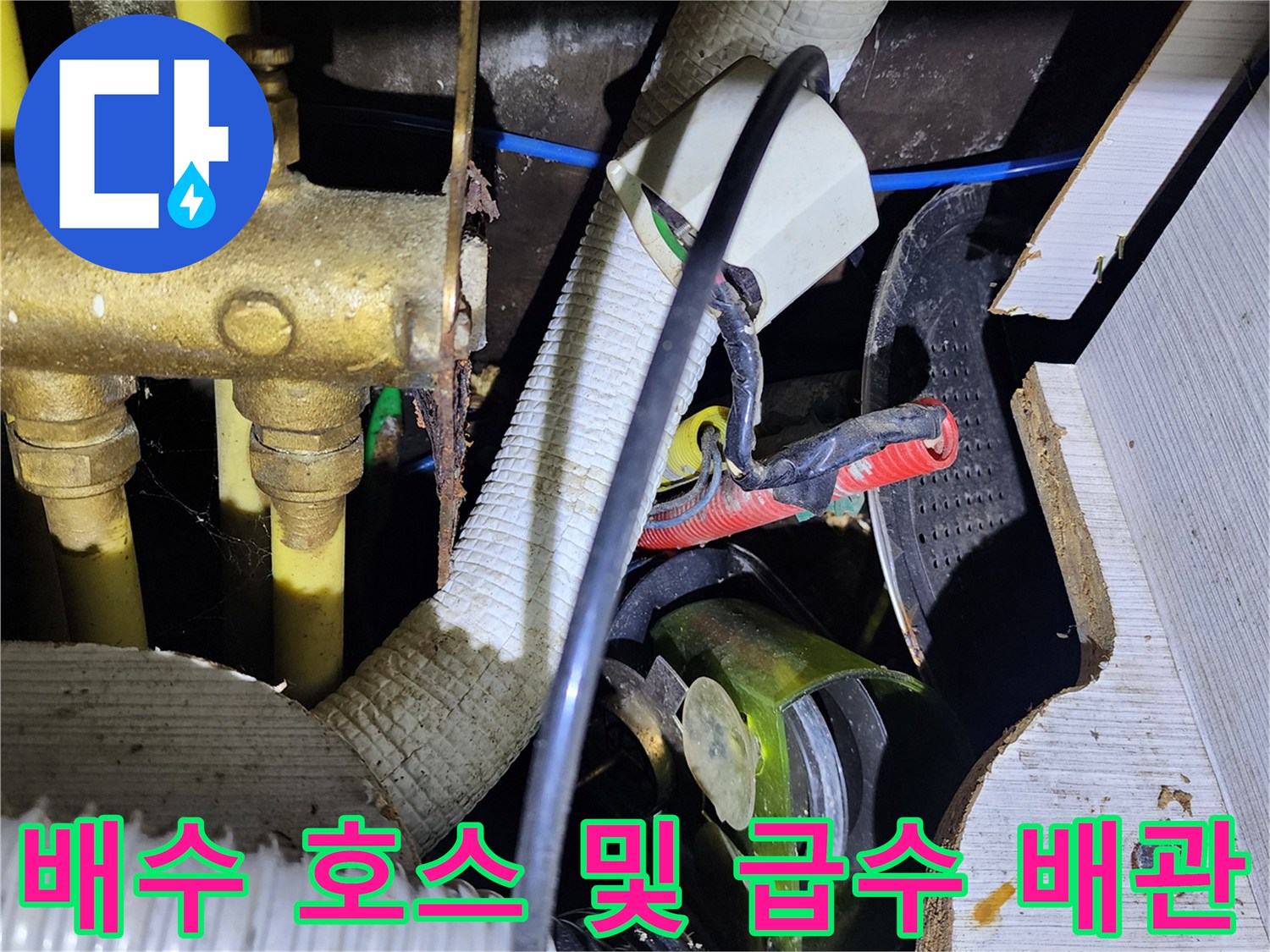 싱크대 하부장 내부의 금속 배관과 주름관 연결 부위 상세 사진