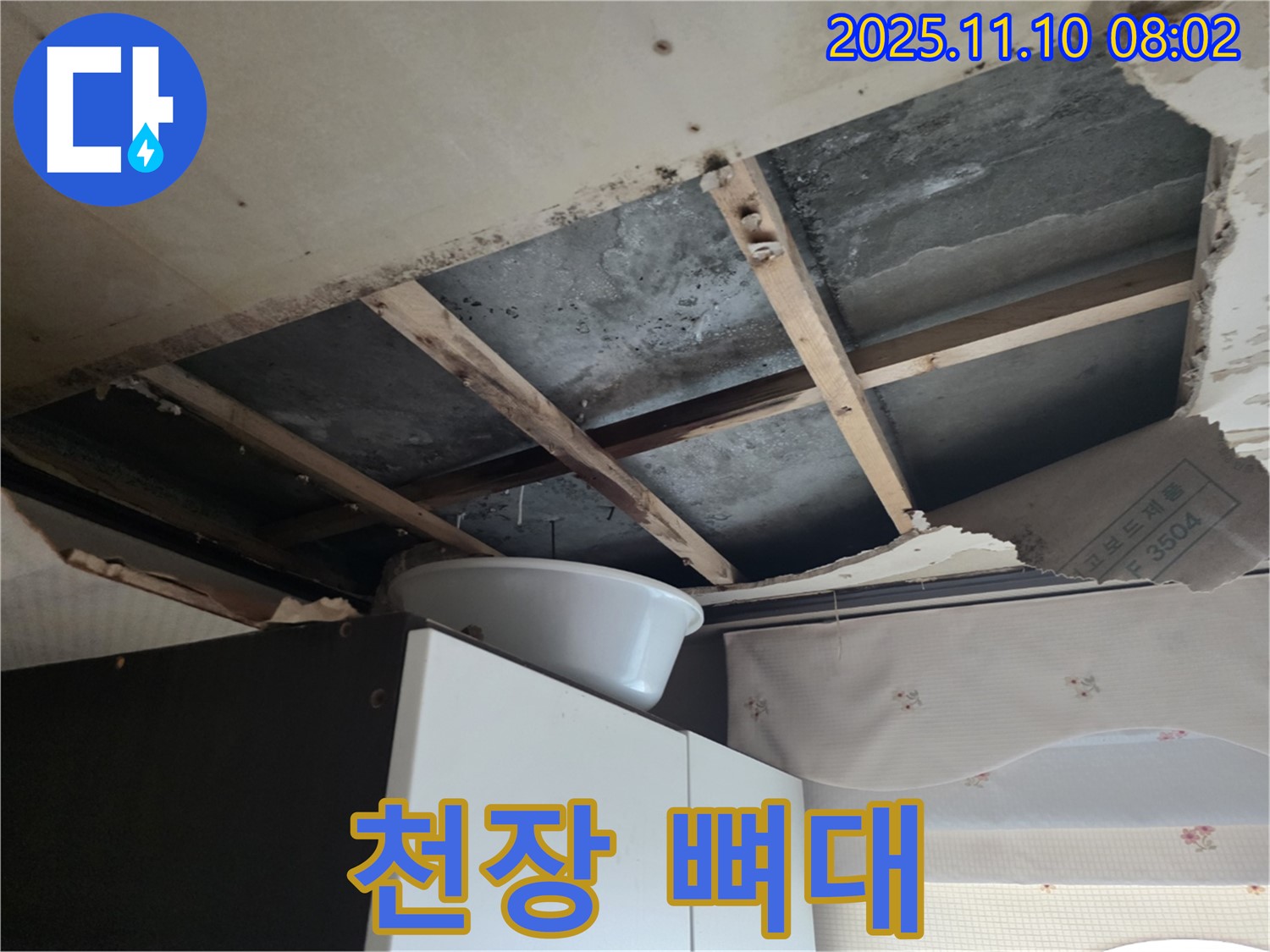 초원맨션 천장 누수 - 천장이 손상되어 나무 뼈대가 드러난 모습입니다.