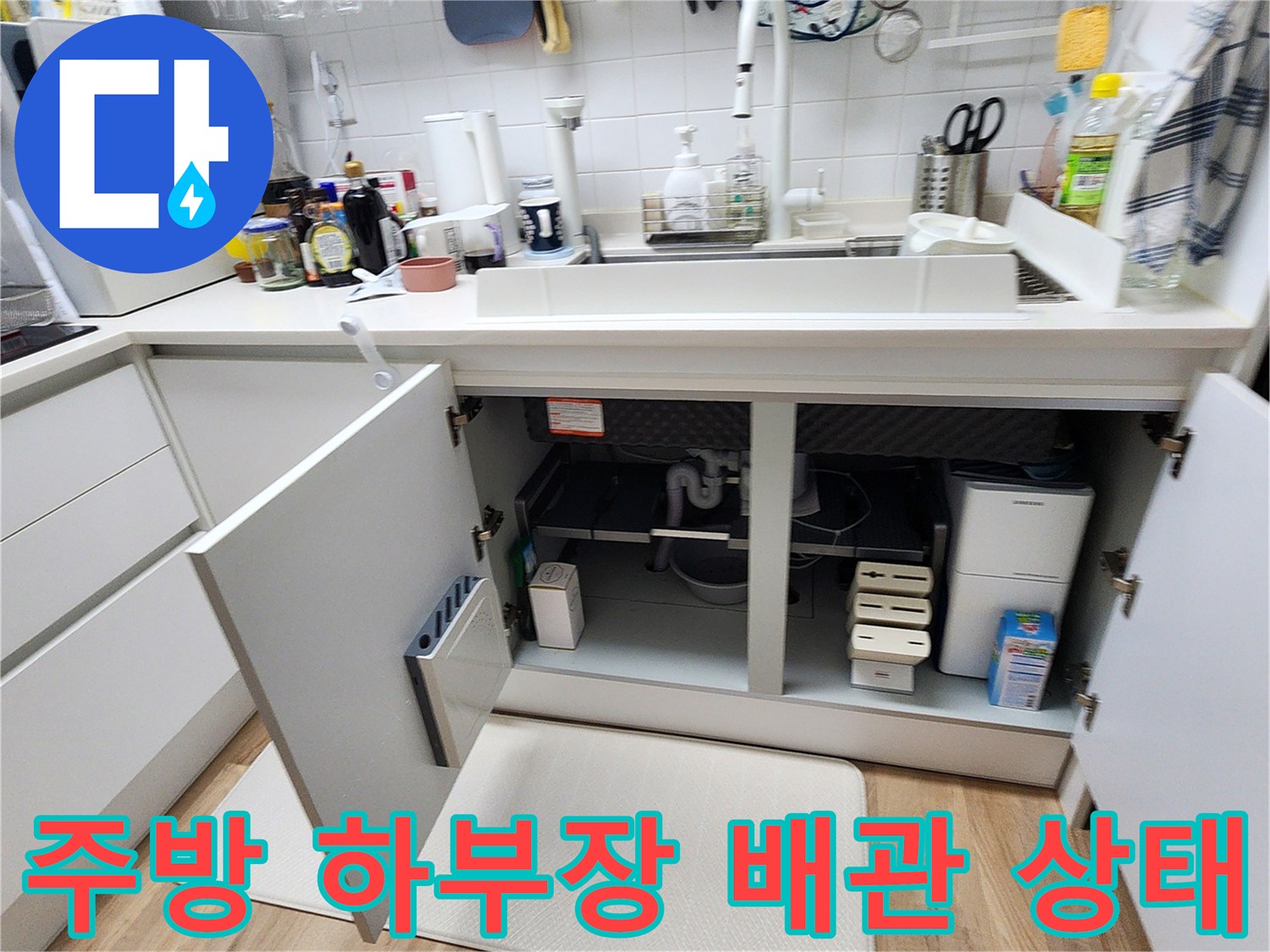 싱크대 밑 공간-노후된 분배기와 배관 연결 부위를 점검하는 장면