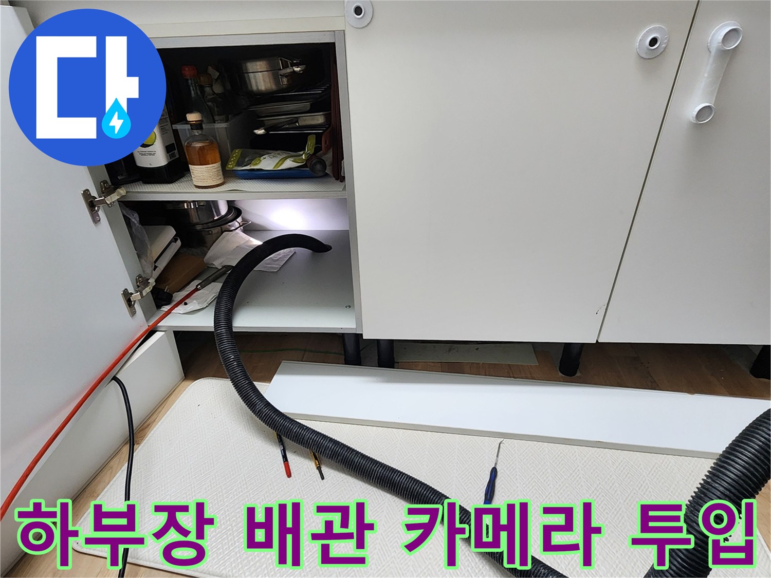 싱크대 하단 배관 내부의 문제를 찾기 위해 내시경 장비를 사용하는 현장