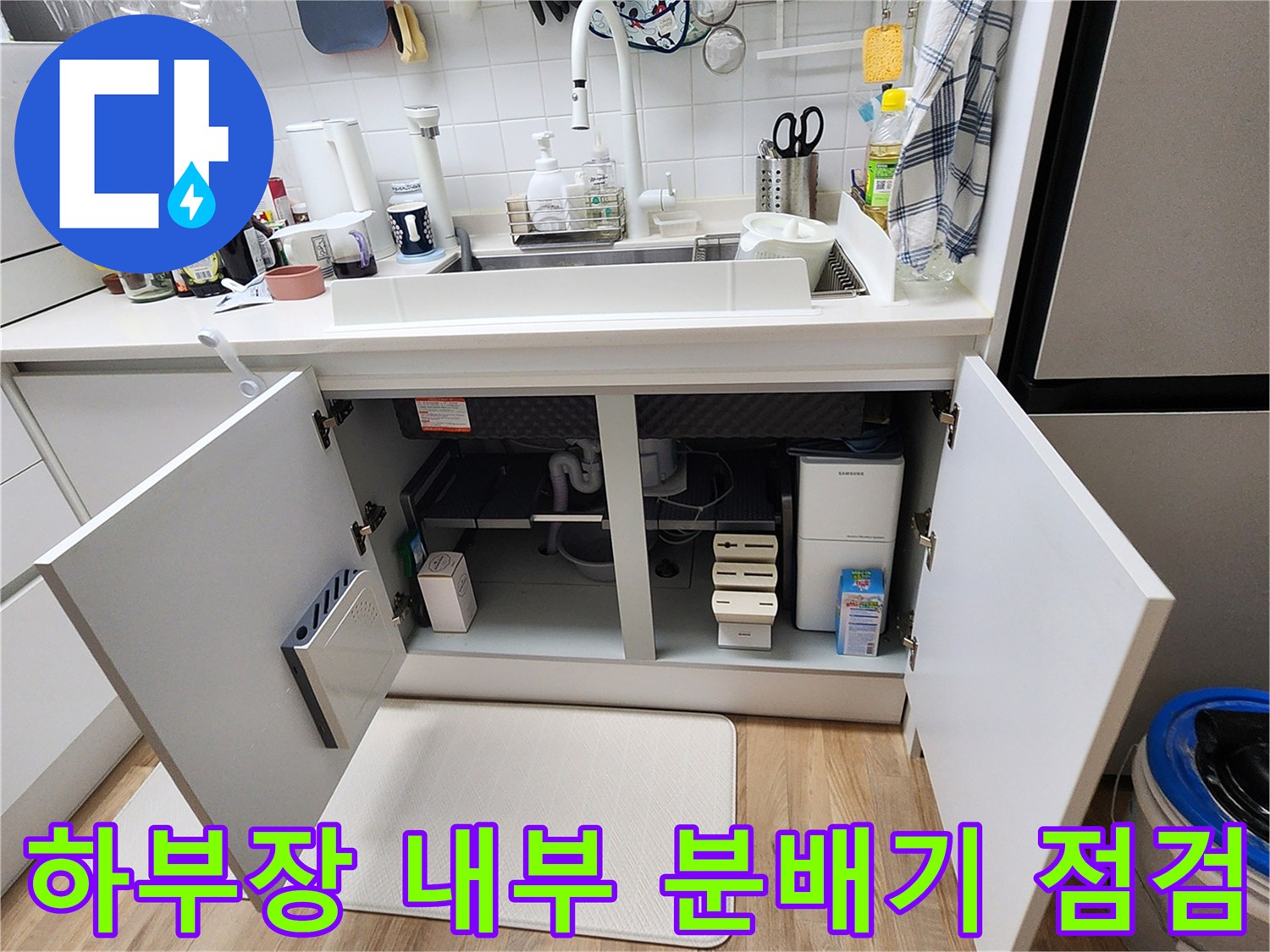 열려있는 싱크대 하부장 내부의 매립된 분배기 부위