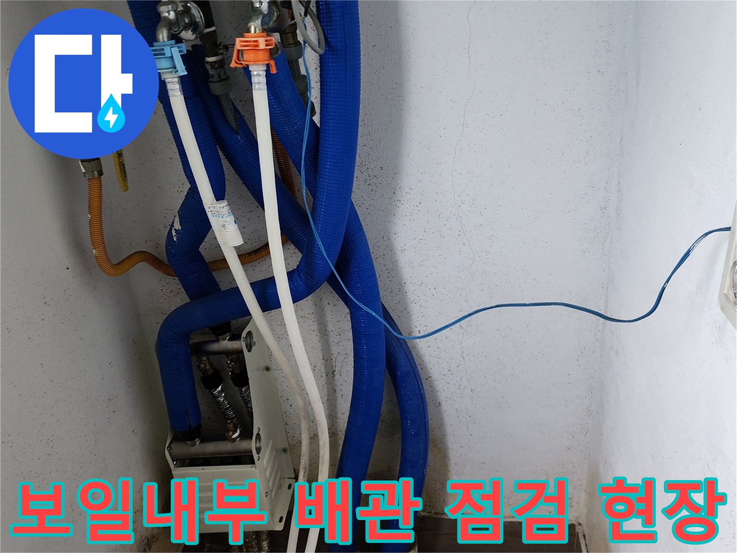 보일러실 내 파란색 및 흰색 배관의 연결 부위 상세 사진