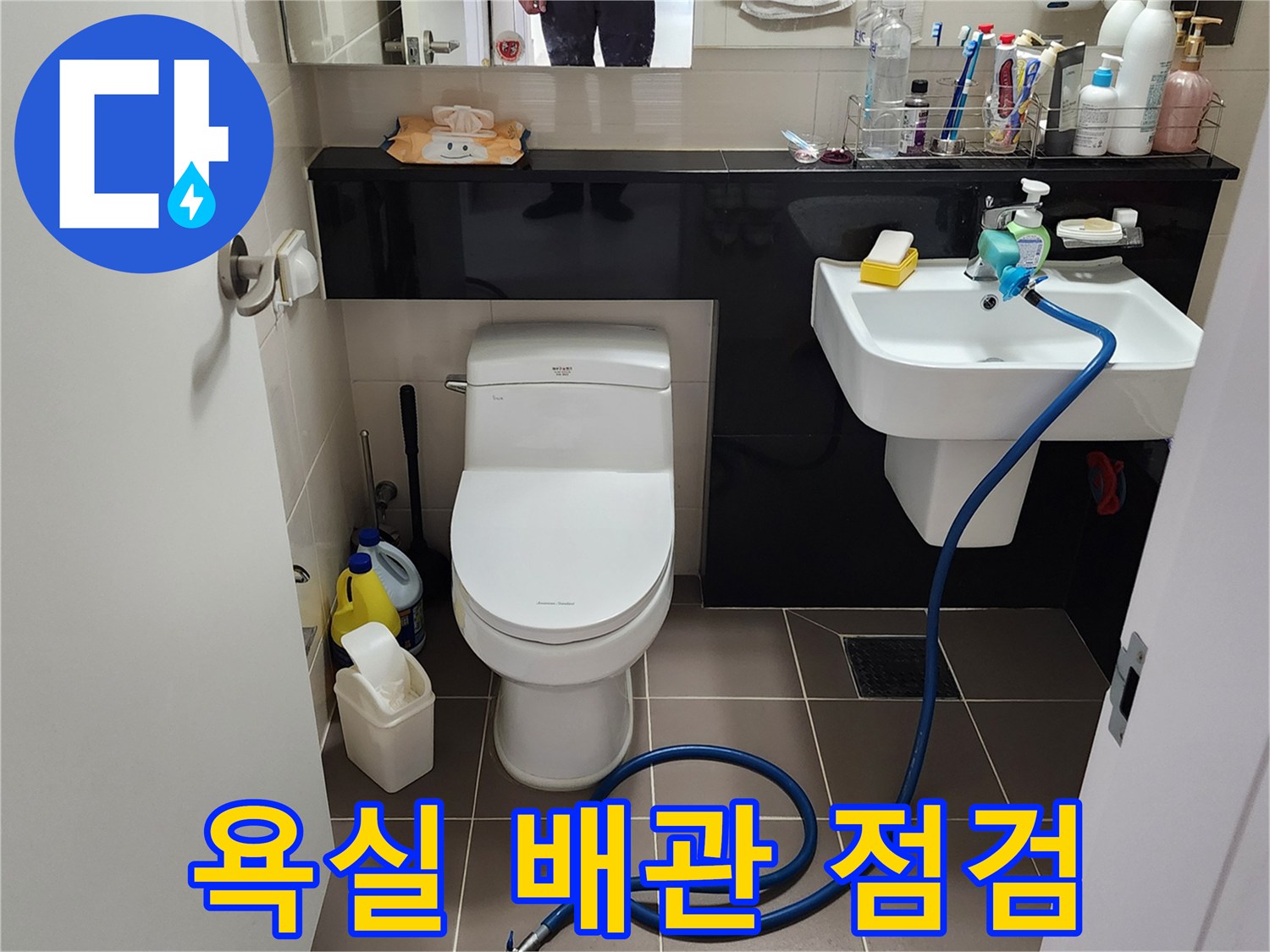 세면대 하단에 연결된 파란색 검사용 호스와 바닥 배관 상태