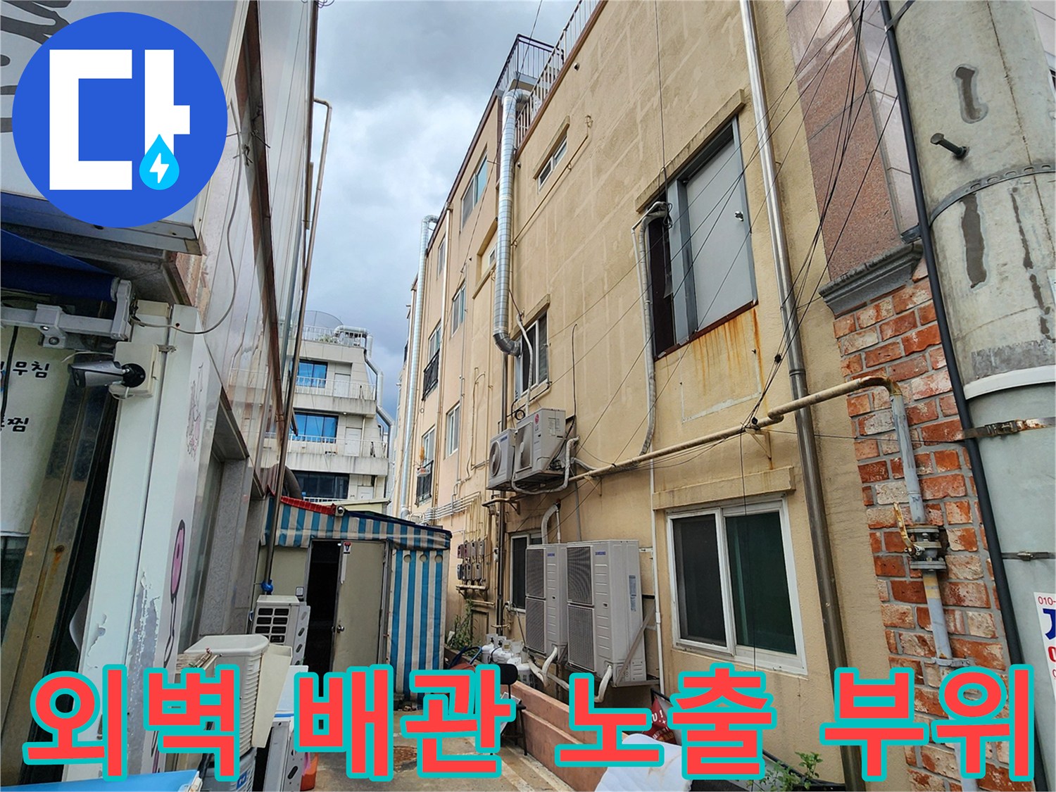 건물 외벽-실외기와 연결된 배관들의 설치 상태를 촬영한 사진입니다.