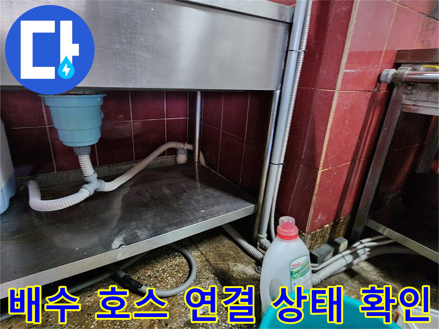 싱크대 하부 배수 호스와 벽체 배관의 연결 지점 근접 촬영