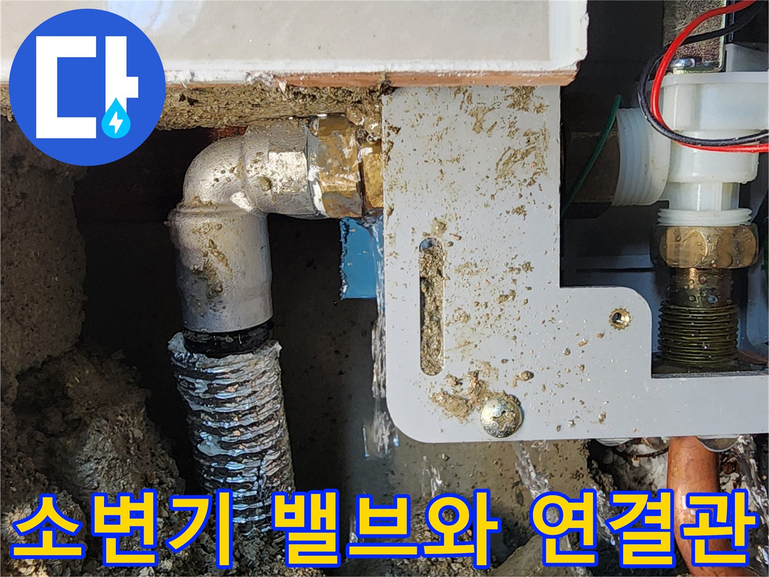 벽면을 제거하여 드러난 소변기 자동 세척 장치와 급수 라인입니다.