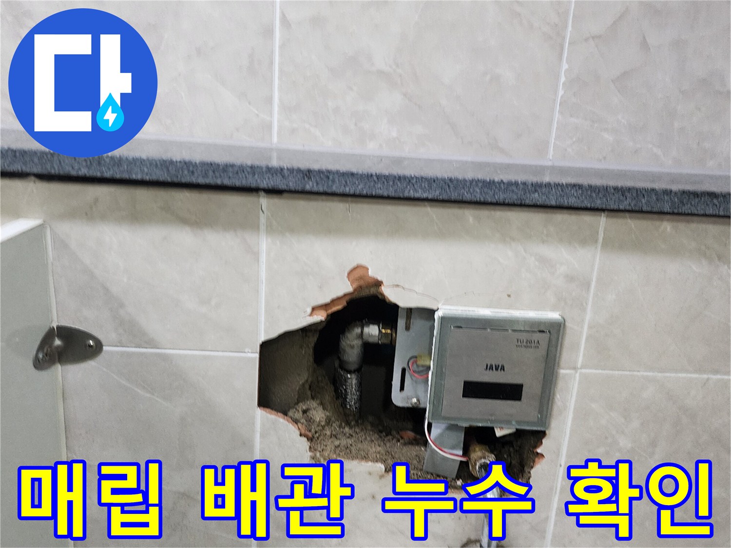 타일이 제거된 벽면 내부의 소변기 급수 밸브와 노출된 금속 배관을 보여줍니다.
