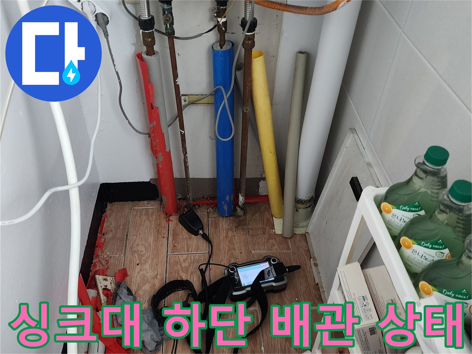 복잡하게 연결된 싱크대 하부 배관과 누수 진단용 장비 세트