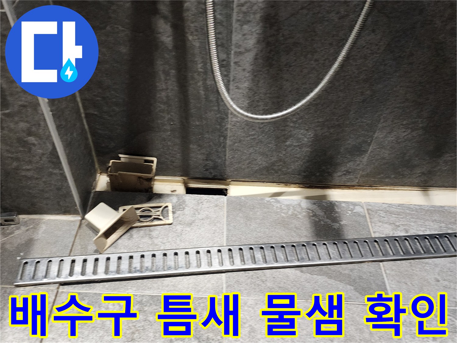 욕실 배수 트랩과 타일 경계면의 파손된 상태를 보여주는 사진