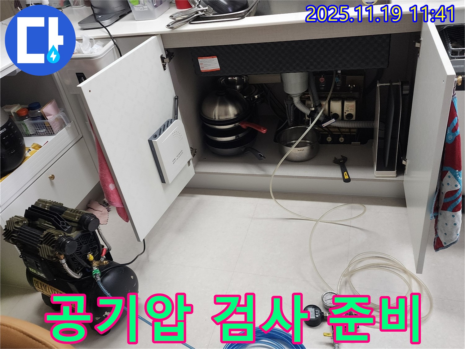 포천시 내촌면 마명리 누수 현장 - 싱크대 하부에서 공기압 검사를 위해 장비를 연결하고 준비하는 모습입니다.