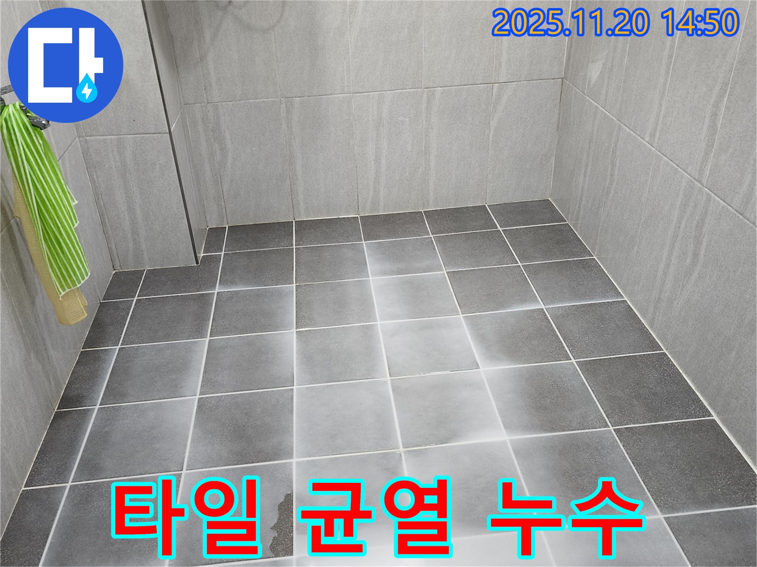 욕실 타일에 생긴 균열과 그 주변에 고인 물 - 타일 손상으로 인한 누수를 보여줍니다.