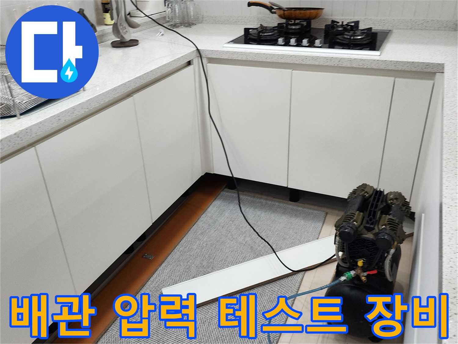 싱크대 밑 공간에 배치된 공기압 검사용 컴프레서와 파란색 호스