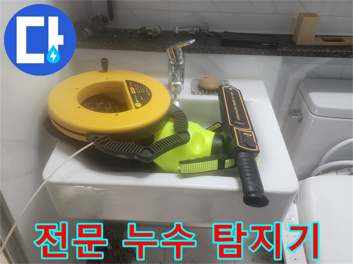 세면대 공간에 놓인 노란색 릴과 검은색 가스식 탐지기 세트