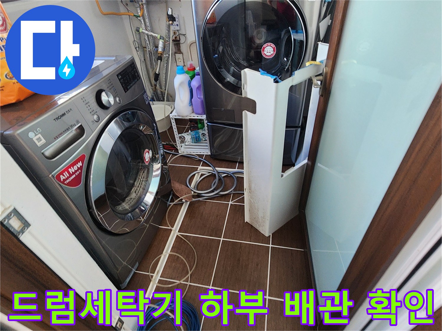 가산면 세탁실 내부의 드럼 세탁기와 건조기 설치 상태와 바닥 배관