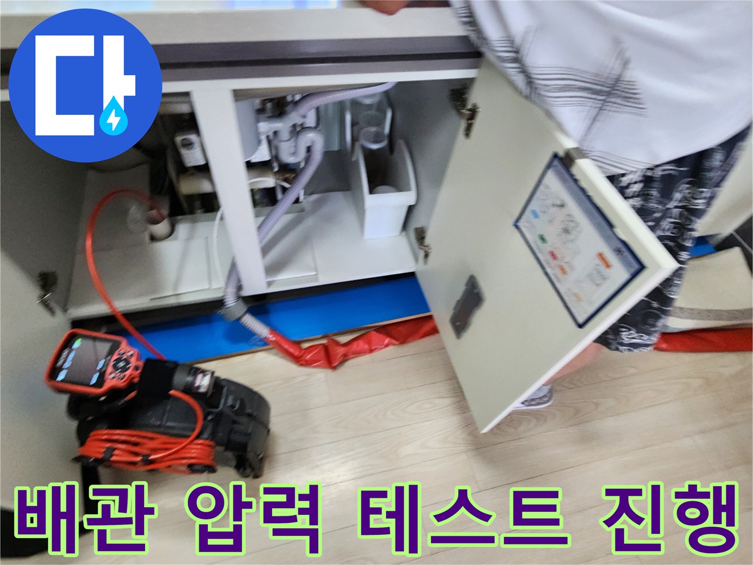 공압-테스트기를-사용하여-싱크대-하부-배관의-압력을-측정하는-장면