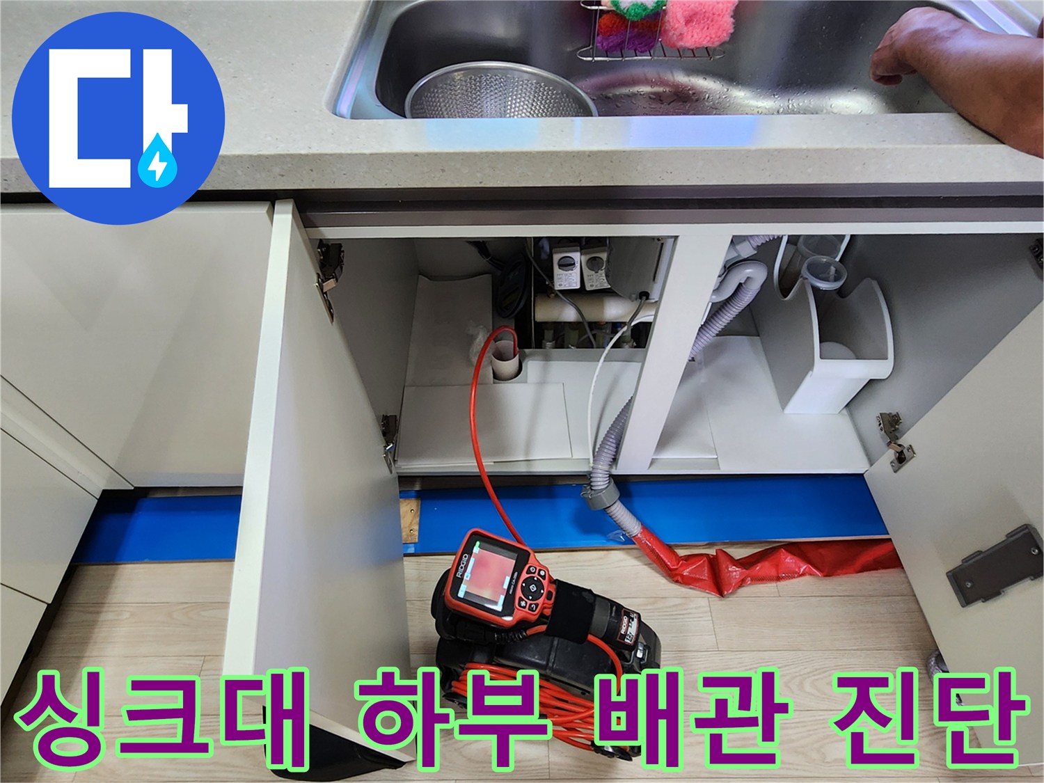 싱크대 아래쪽 배관 부위를 정밀하게 검사하기 위해 장비를 배치한 모습입니다.