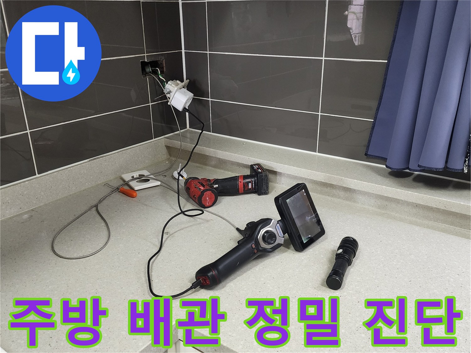주방 싱크대 선반 위에 놓인 배관 내시경 카메라와 탐지 장비