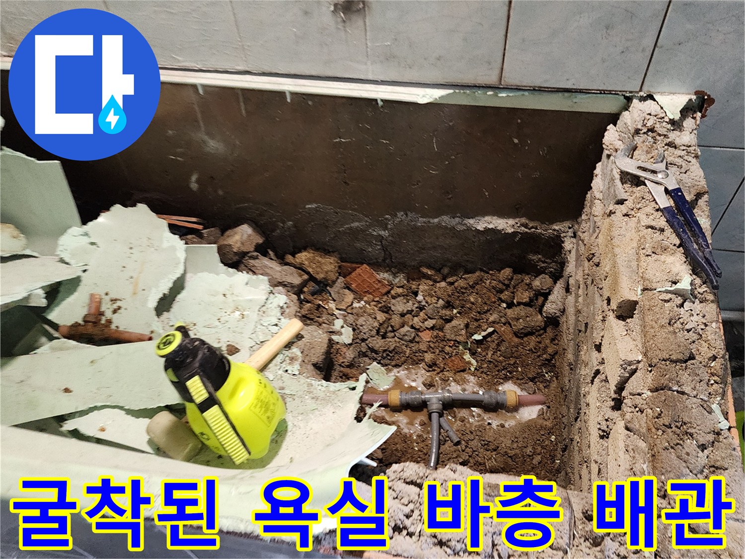 욕실 타일 제거 후 드러난 배관 분기점과 공구들