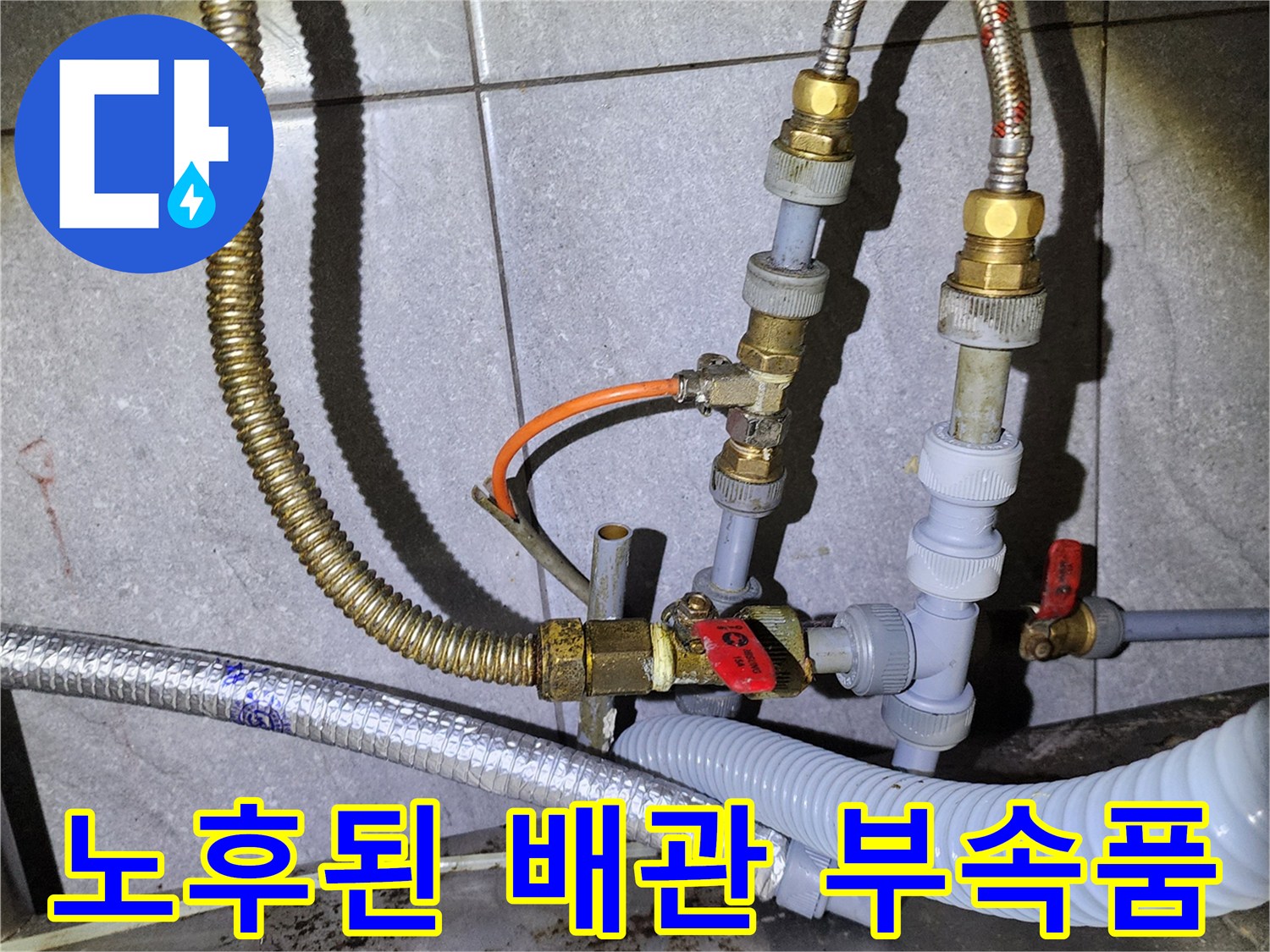 금속 호스와 플라스틱 배관이 연결된 노후 배관의 상세 모습입니다.