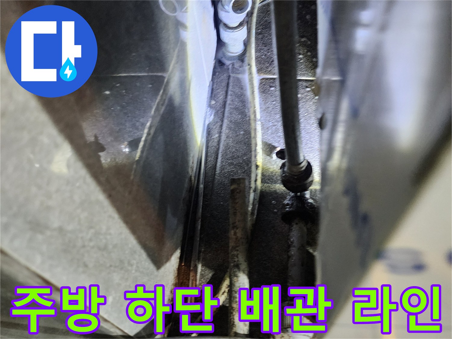 복잡하게 얽힌 주방 하부 배관과 연결 부속의 근접 촬영 이미지