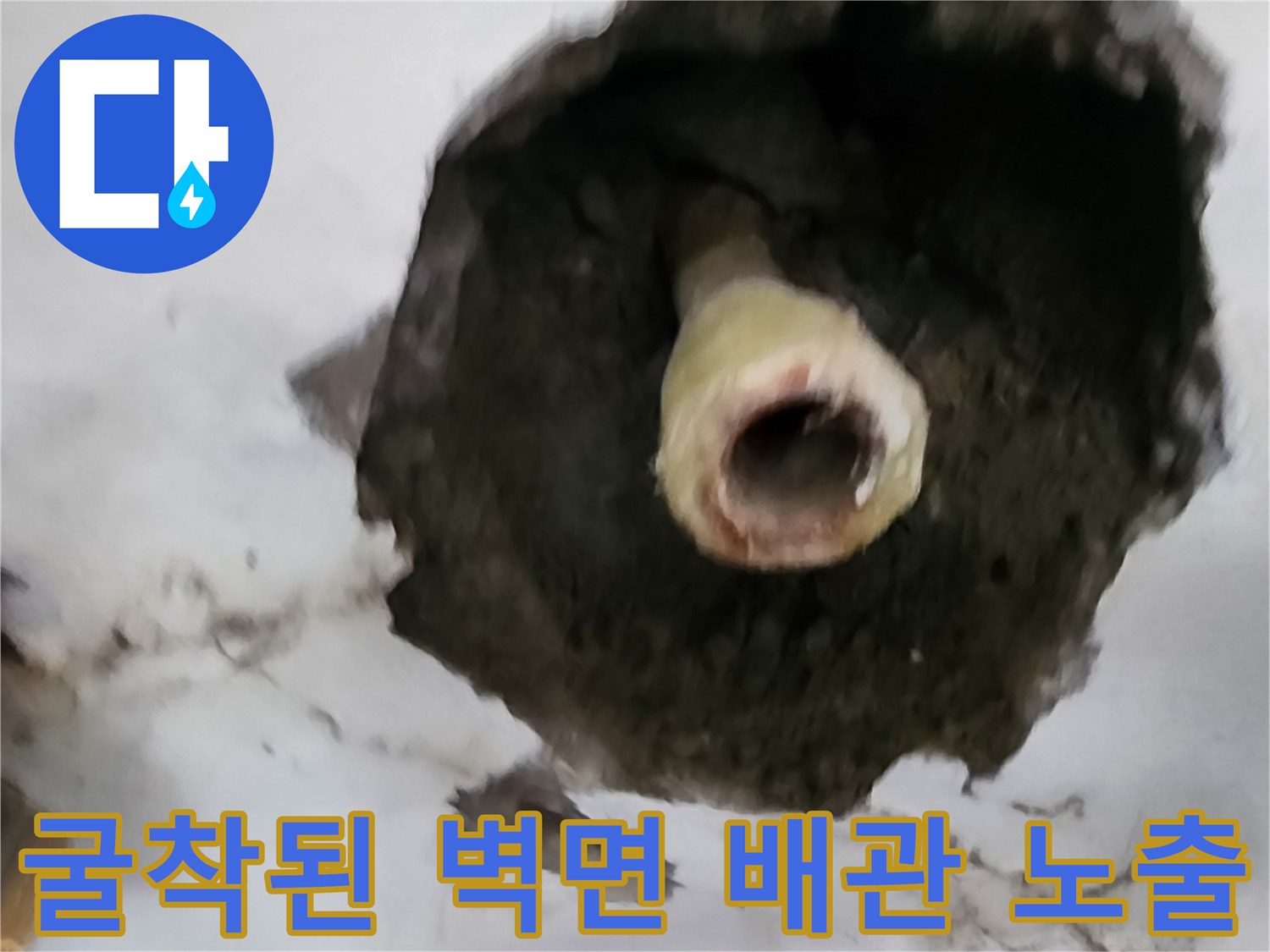 벽을 파낸 자리에 드러난 노후 배관과 주변 시멘트 상태입니다.