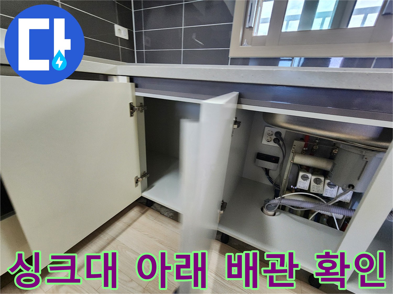 싱크대 내부 공간-노출된 배관과 콘센트 상태