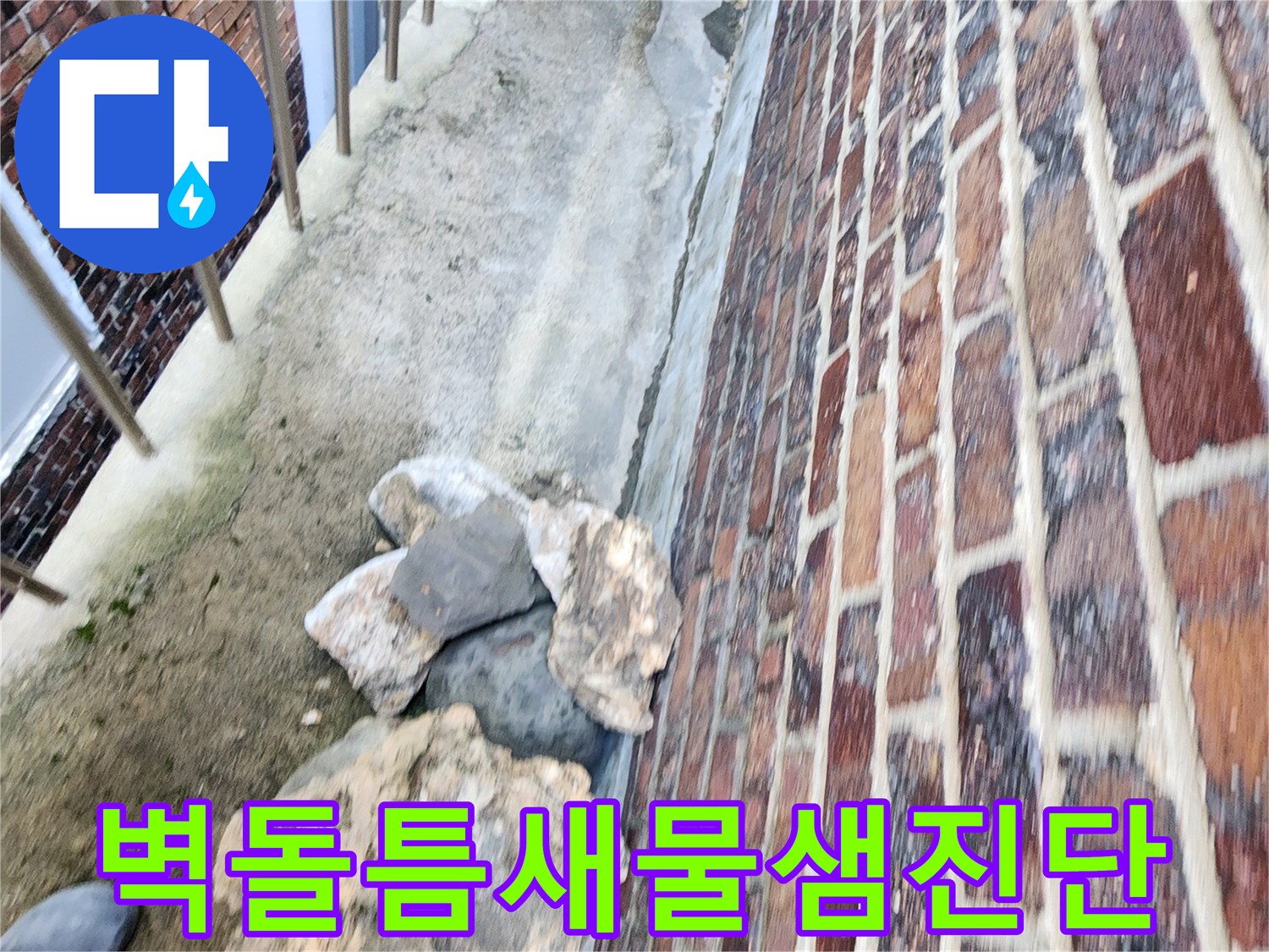 건물 벽돌 하단의 벌어진 공간과 노후된 마감 부위를 보여주는 사진입니다.