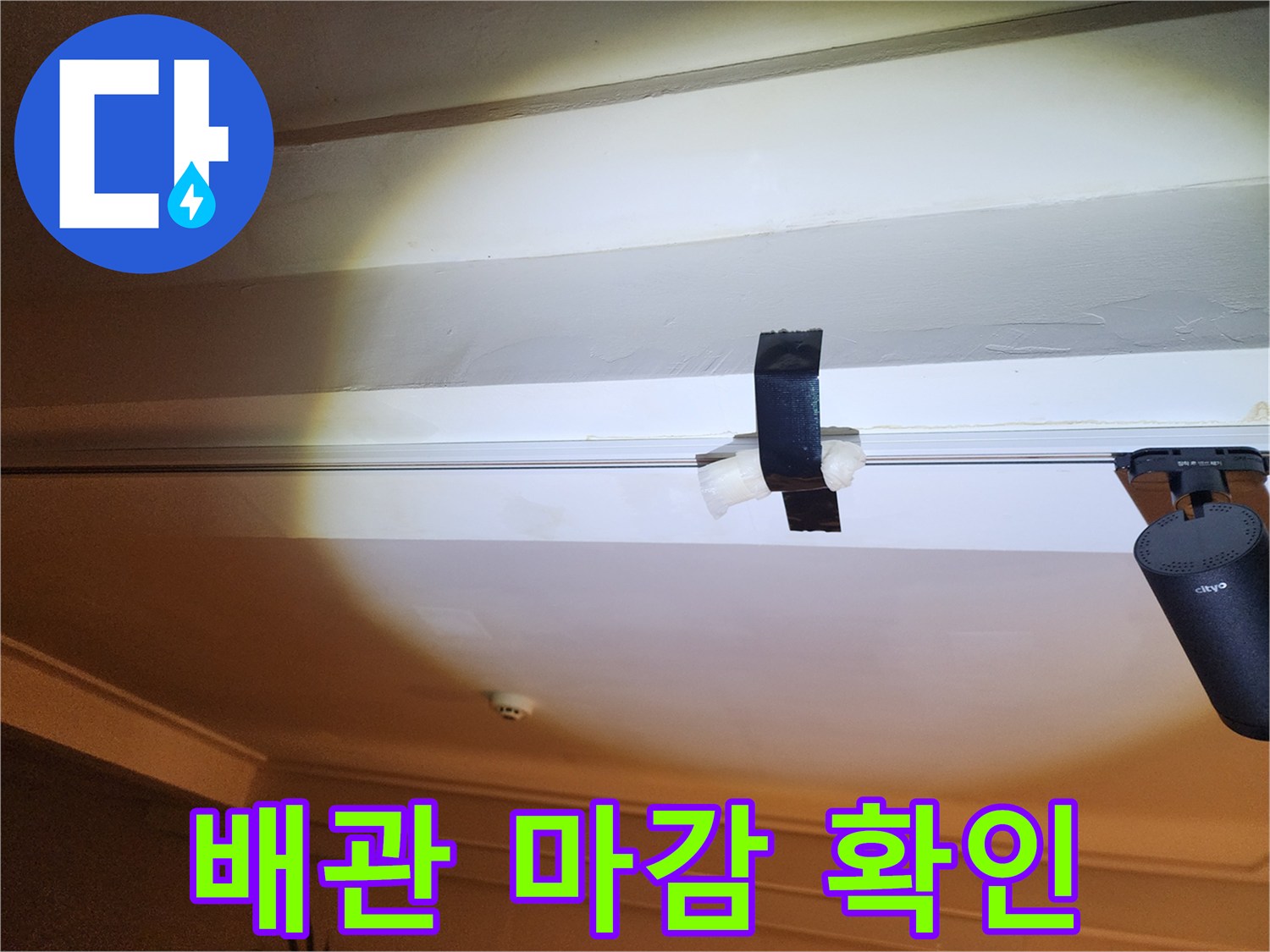 배관을 고정하고 있는 검은색 테이프와 주변 마감 상태를 촬영한 사진입니다.