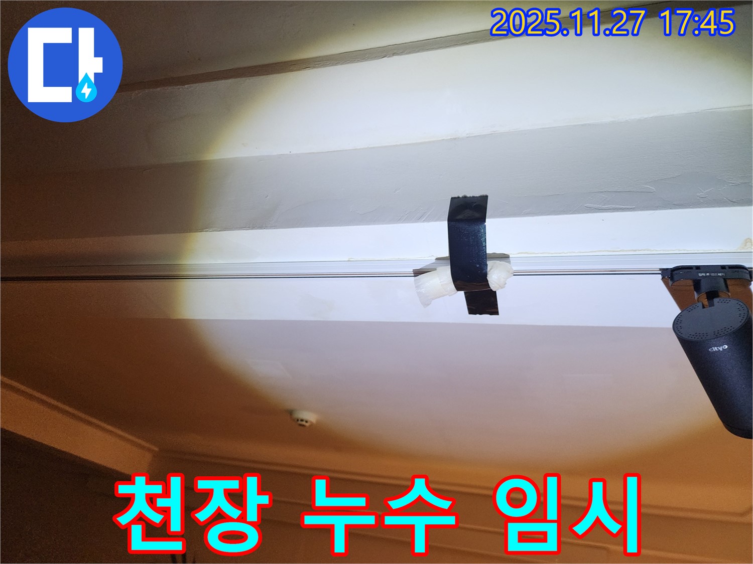 천장 누수 발생 시 임시 조치 - 테이프를 사용하여 물이 떨어지는 것을 막고 있는 모습
