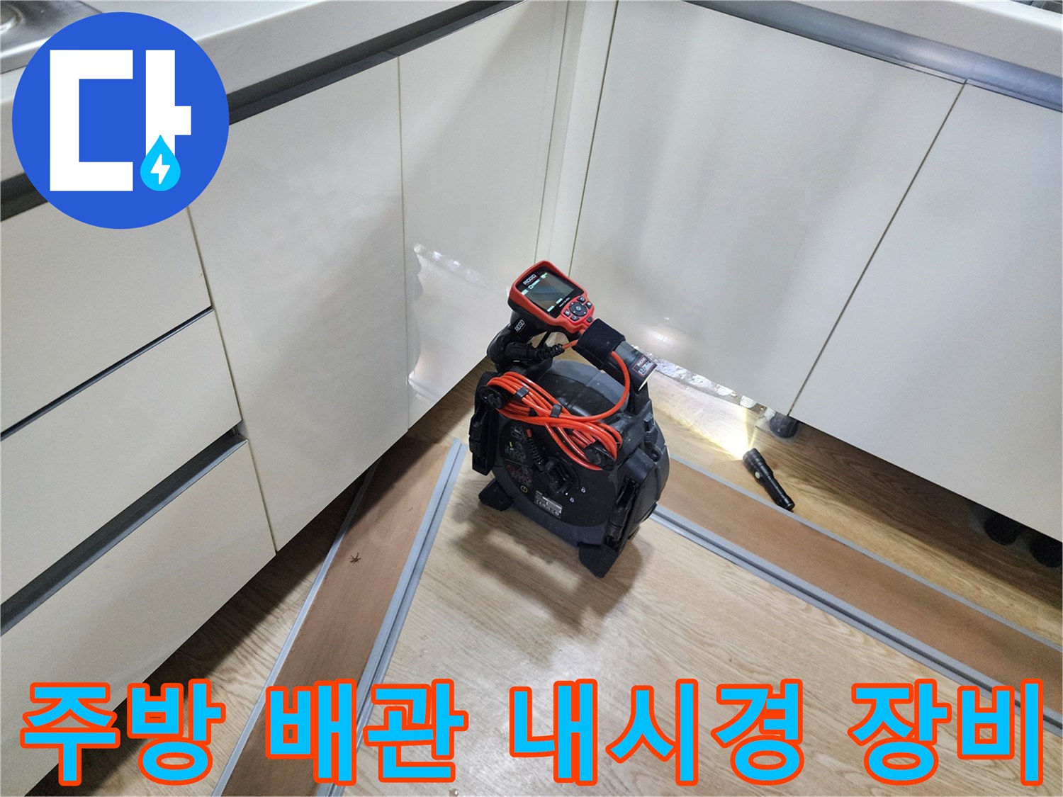 싱크대 하부 공간의 배관 상태를 확인하기 위해 배치된 내시경 카메라와 모니터